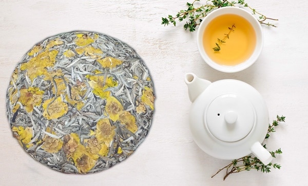Trà shan tuyết có nhiều công dụng cho sức khỏe và sắc đẹp - sản phẩm bạch trà ép thành bánh với hoa